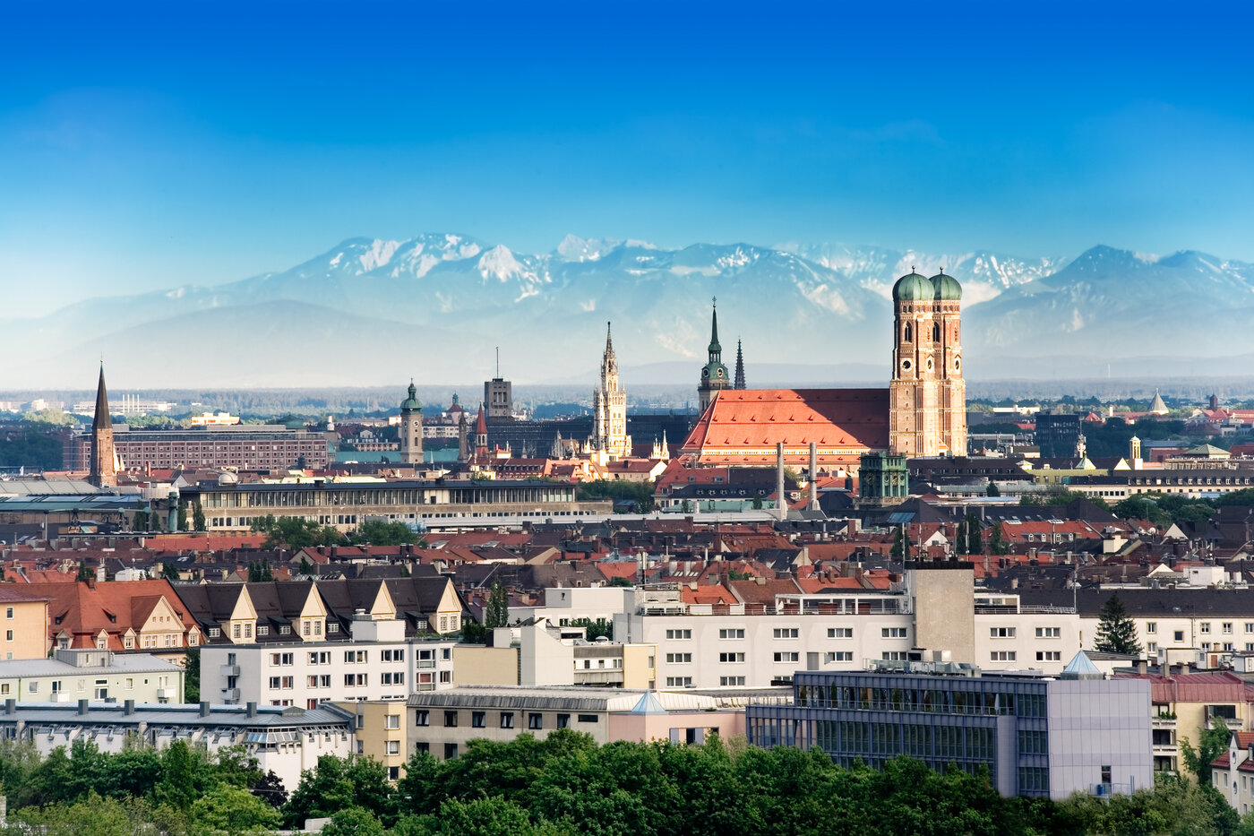 Munich, capital city of Germany's Free State of Bavaria. CIty skyline in the evening light. The Alps visible in the background.